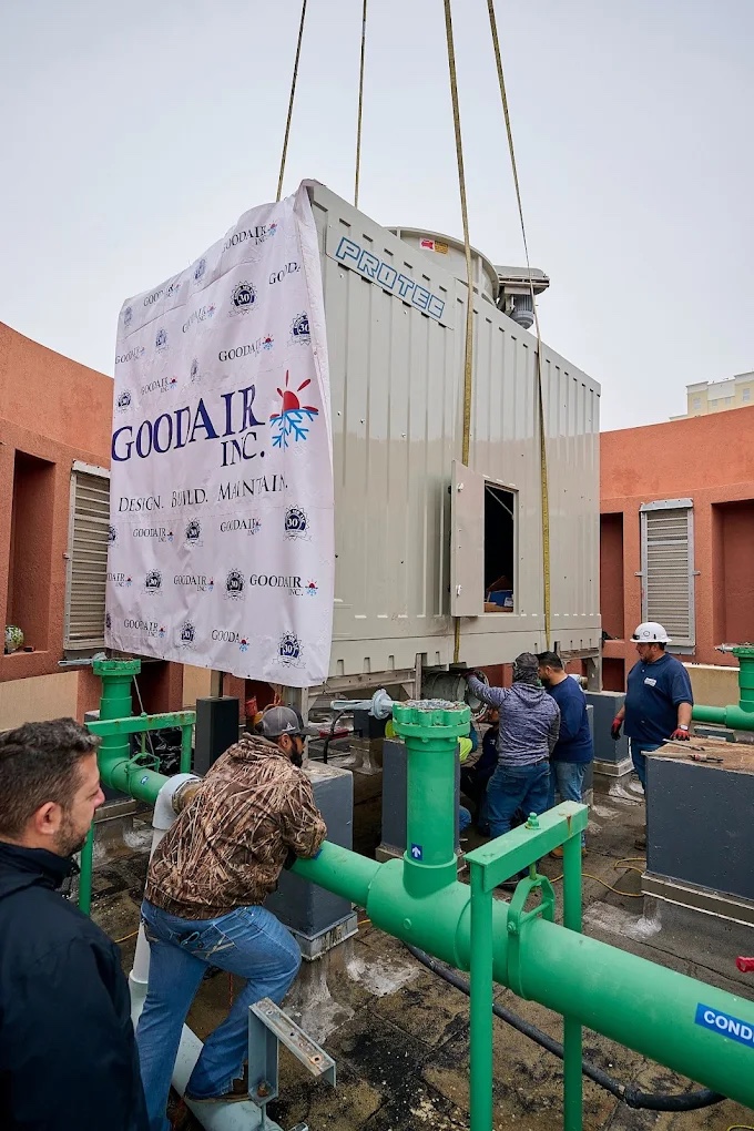 Good Air crew guiding a cooling tower into place during a rooftop crane lift